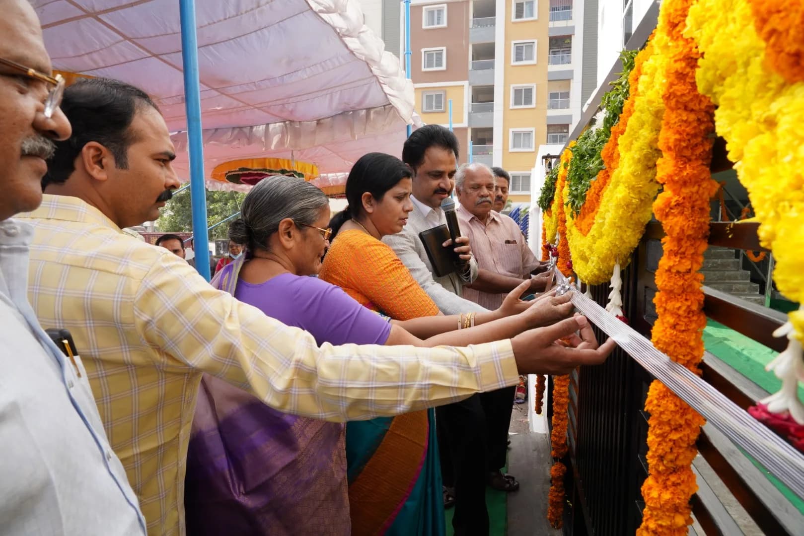 Marigold garlands hung for a dedication ceremony as the congregation gathers