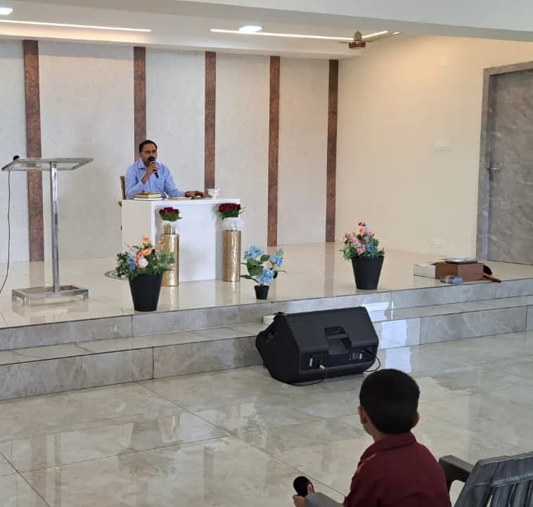 A pastor preaching from the lectern on the sanctuary platform while the congregation listens