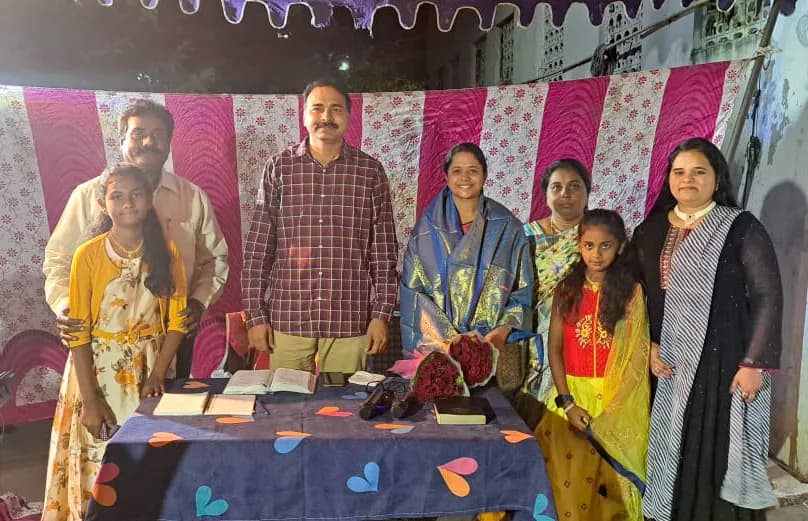 A family standing together behind a decorated table at a church gathering